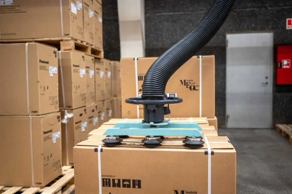 Behrens Logistik anvender en vakuumløfter til sikker og effektiv håndtering af papkasser på lageret. Moderne logistikløsninger.