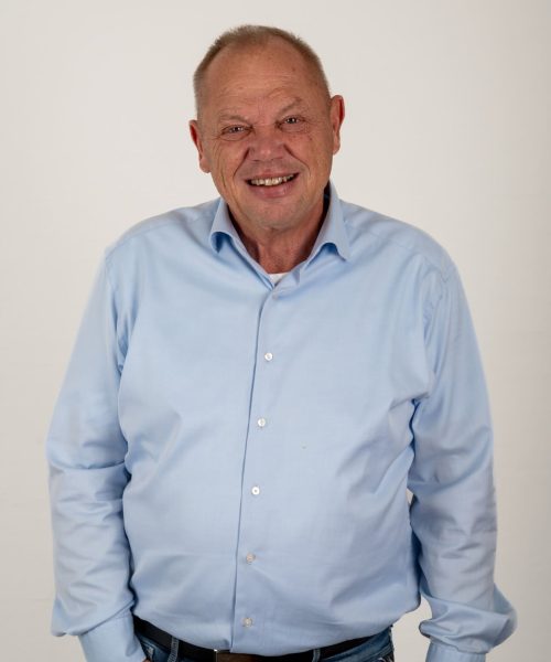 Glad mand i lyseblå skjorte hos Behrens Logistik, klar til at hjælpe med logistikløsninger.