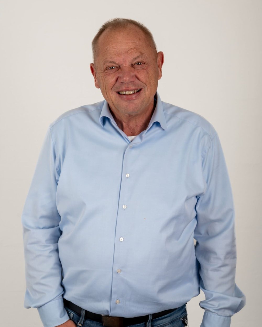 Glad mand i lyseblå skjorte hos Behrens Logistik, klar til at hjælpe med logistikløsninger.