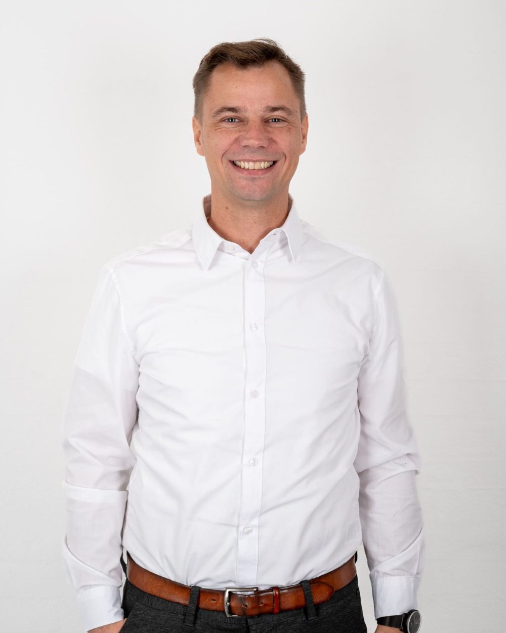Glad mand i hvid skjorte og brunt bælte, medarbejder hos Behrens Logistik.